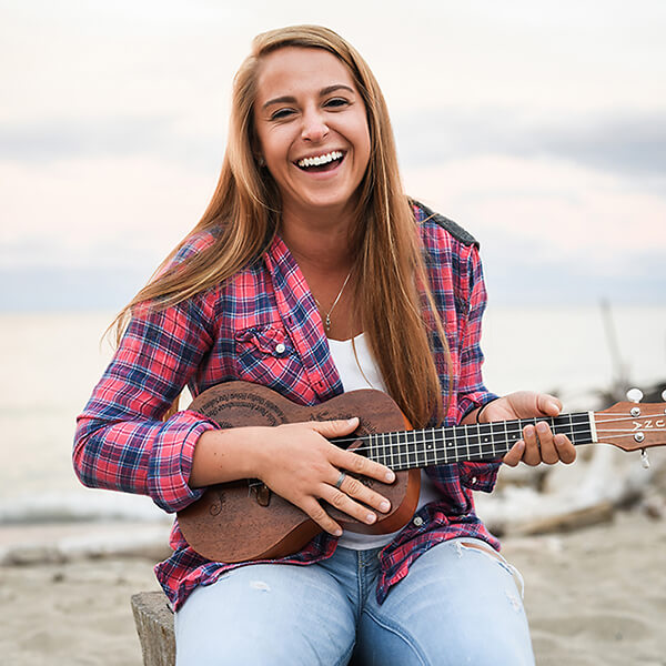 A student plays the ukulele at the beach